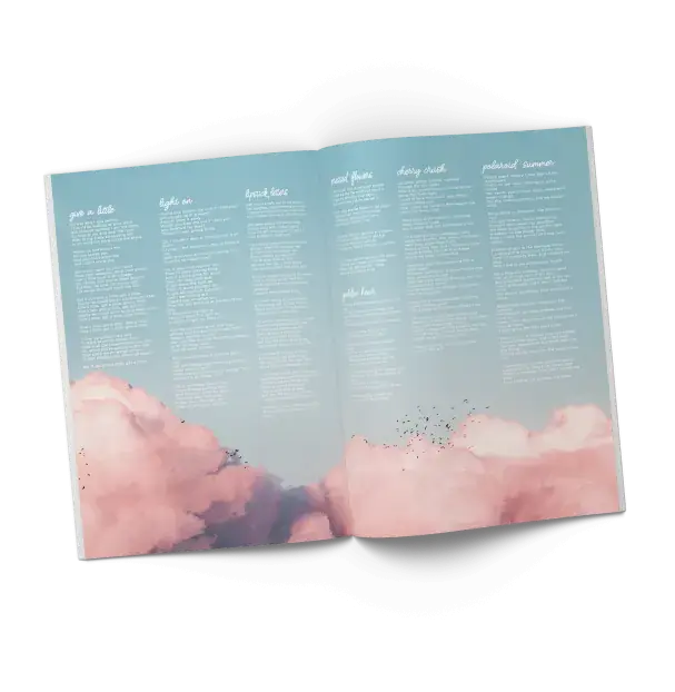 An open booklet displaying two pages with a light blue background and pink clouds at the bottom. The pages are filled with song titles and lyrics in white text in a small font, arranged in multiple columns.